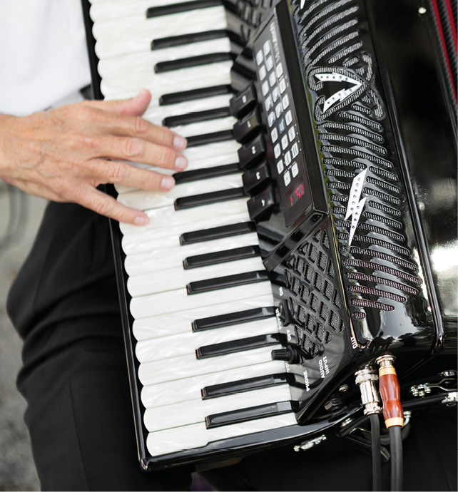 A close up of a musician's hands playing the accordion