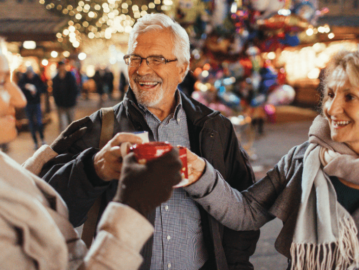 Three people holding glasses of wine and celebrating together