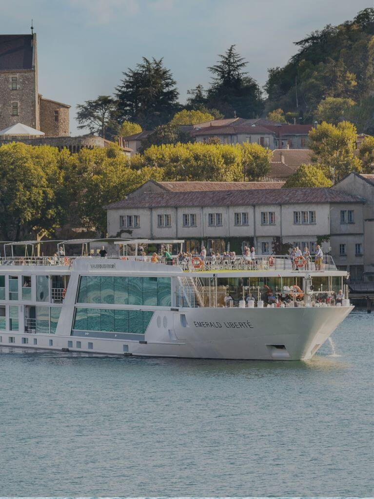 Emerald Liberté river cruise ship sailing past historic buildings