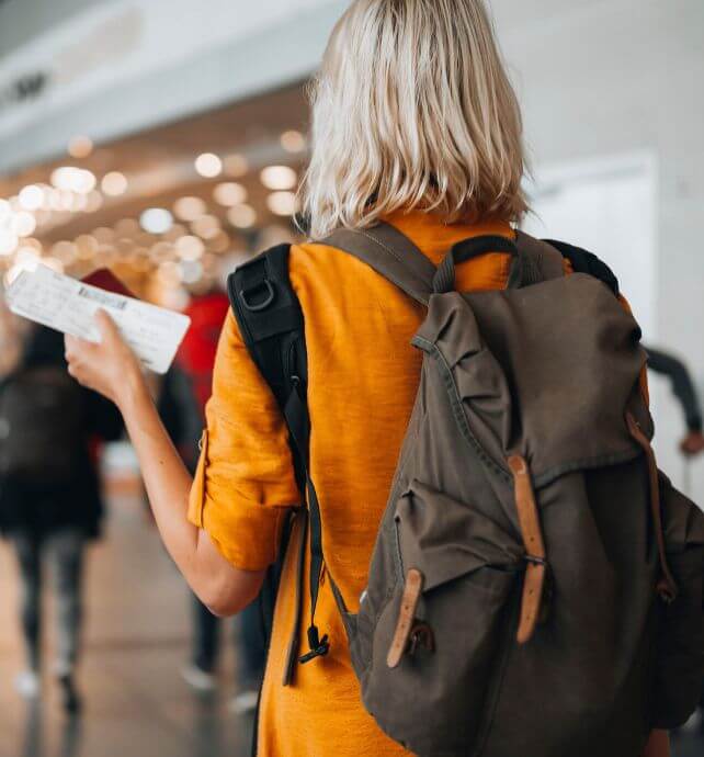 Woman holding a boarding pass and passport at the airport.