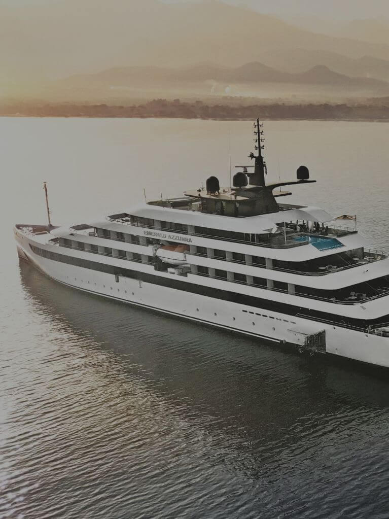 Yacht Emerald Azzurra anchored on calm waters at sunrise.