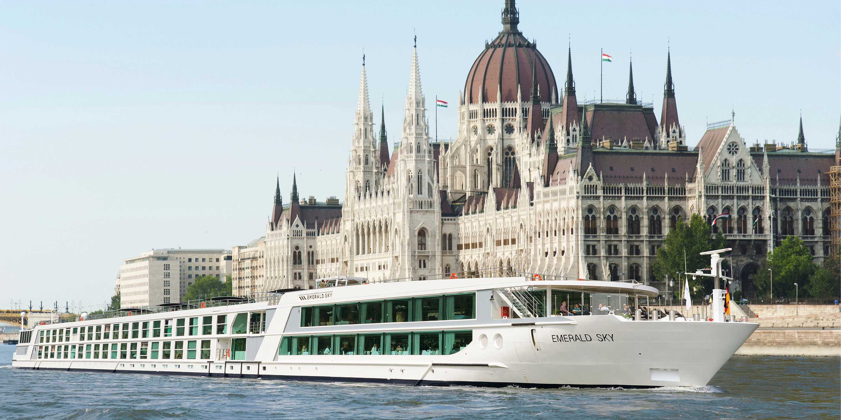Luxury cruise ship sailing the Danube River past the Hungarian Parliament Building in Budapest
