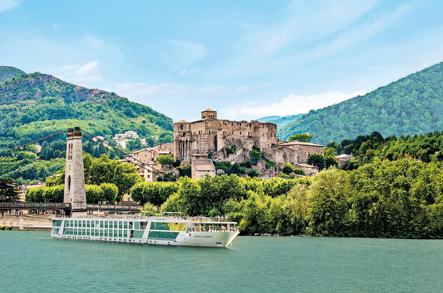 Luxury river ship sailing the Rhône River past an ancient castle in the South of France