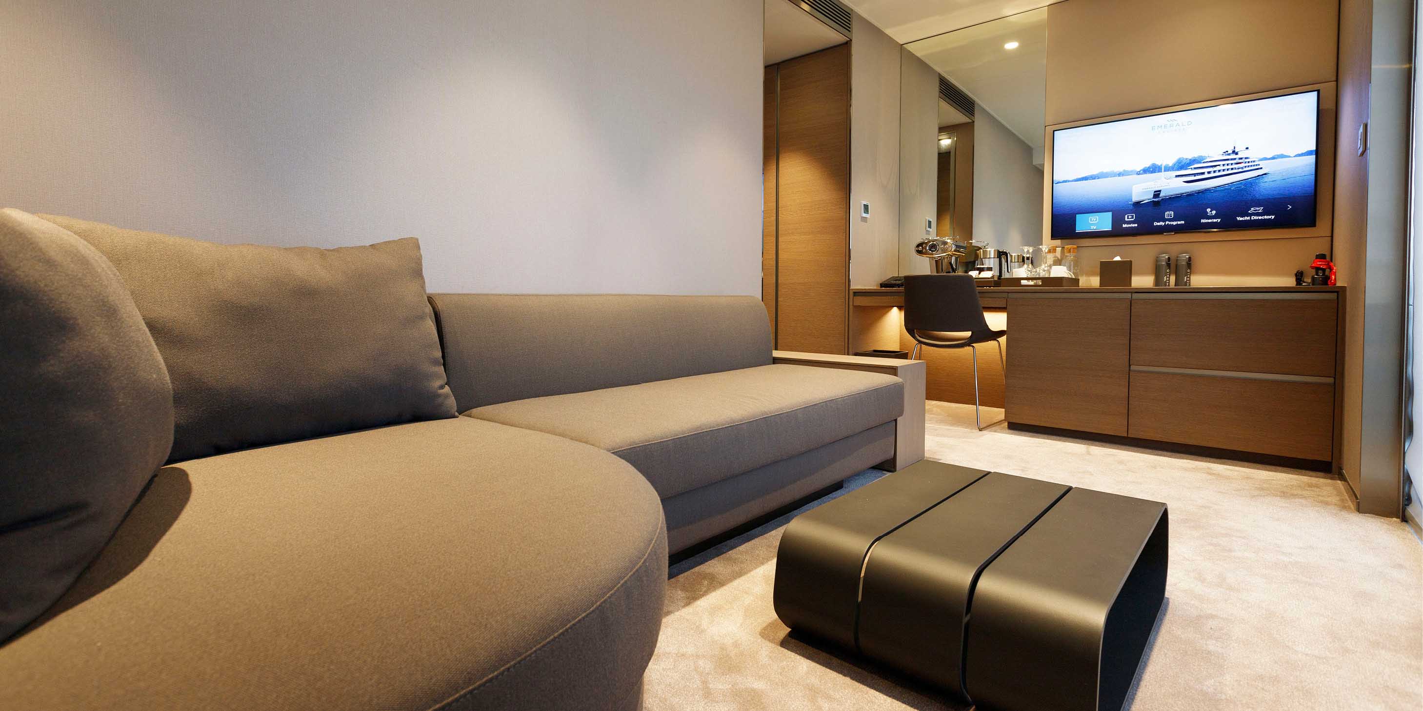 A large cabin on board an Emerald Cruises yacht with a separate lounge area for relaxing and watching TV