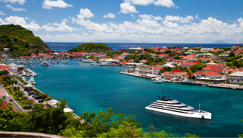 A luxury yacht docked in Bonifacio Corsica, as the sun sets and ripples form in the water